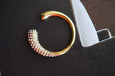 Gold-tone crystal curve ring with full rhinestone band and open C-shaped design