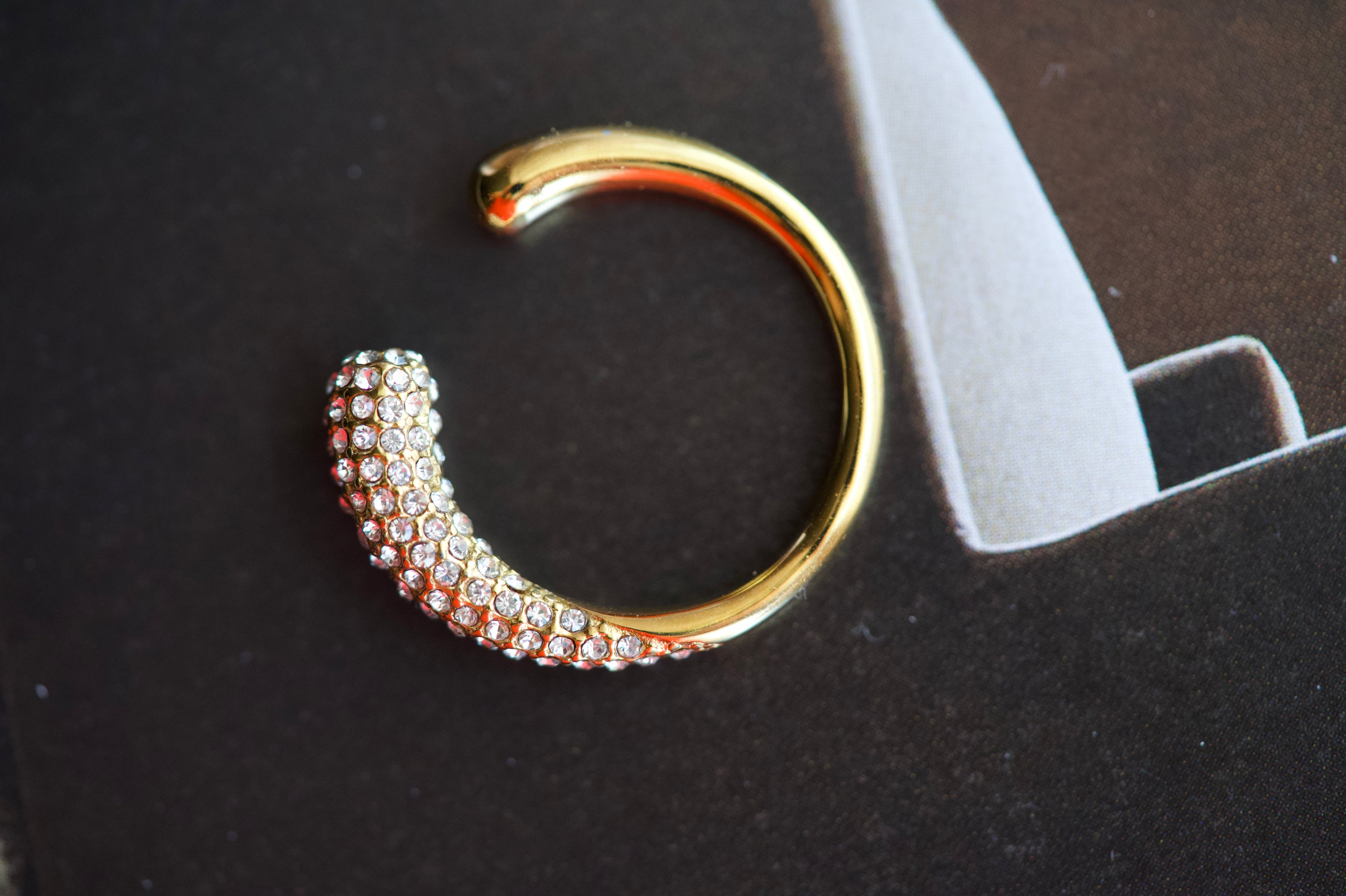 Gold-tone crystal curve ring with full rhinestone band and open C-shaped design