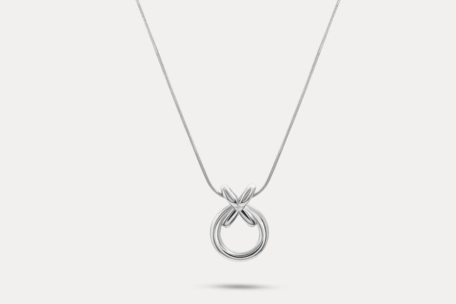 Circle pendant necklace with silver-tone round charm and linked X detail