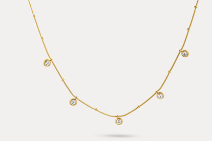 Gold charm necklace with evenly spaced round blue stone charms