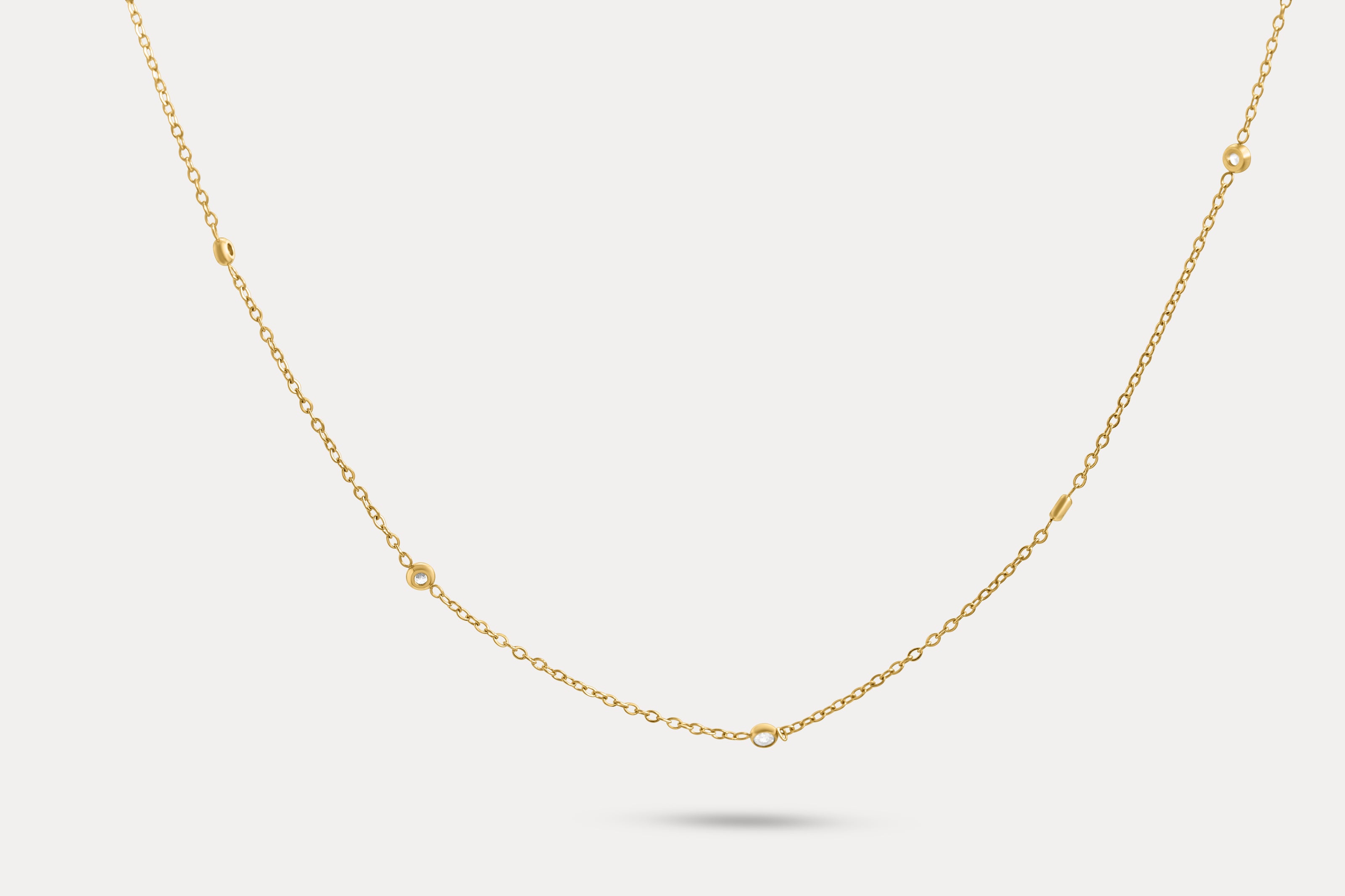 Gold chain necklace with tiny round crystal accents spaced along the length